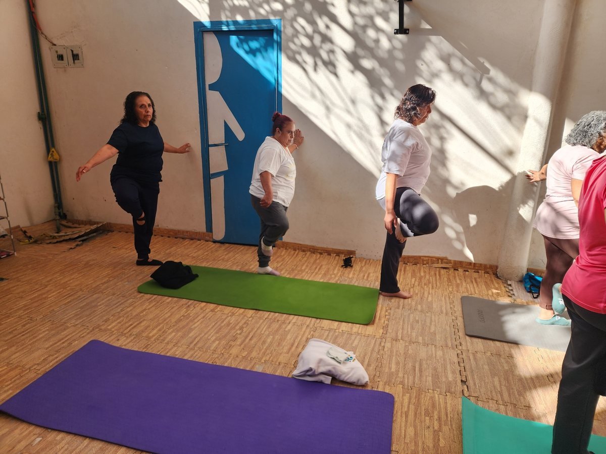 Alumnas practicando ejercicios de equilibrio durante una clase de YogaLu