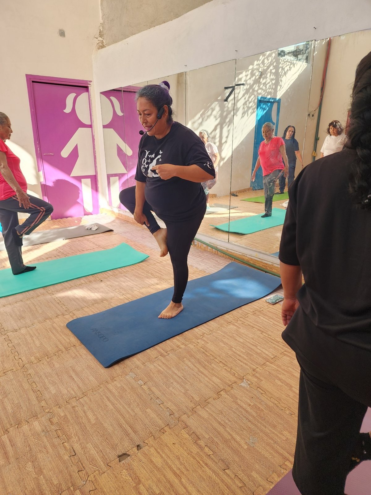 Instructora de YogaLu demostrando un ejercicio de equilibrio frente al grupo
